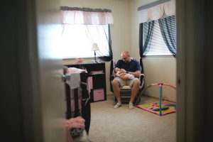 Dad and new baby in nursery.