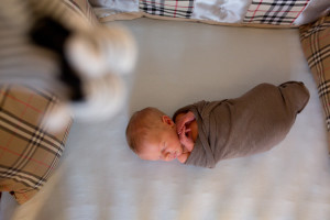 baby boy wrapped in burberry crib