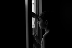 boy standing in front of window