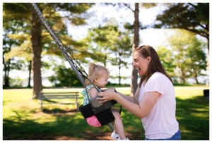 mom plays with daughter in swing