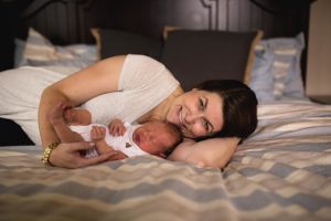 woman laying down in bed with newborn baby