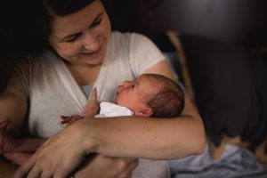 mom looking down at baby with her arms wrapped around the her
