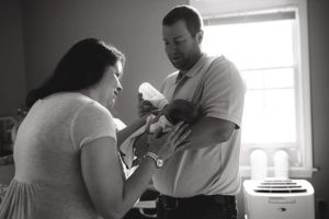 new mom and dad feeding baby
