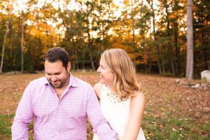 a couple i the fall sitting together with autumn leaves around