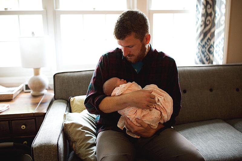 dad with newborn baby in their home