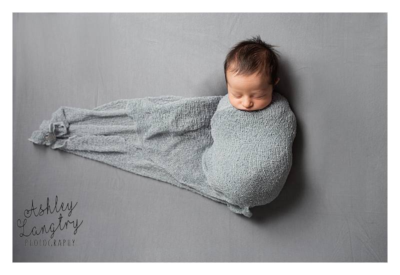 baby wrapped on grey backdrop