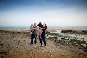 family plays together on the beach
