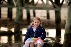 little girl sits on rock in silver sands