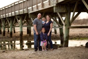 family poses in front of pier at silver sands