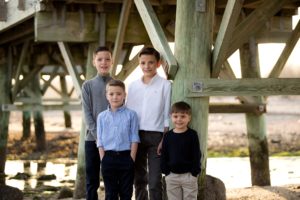 brothers pose for picture on under pier