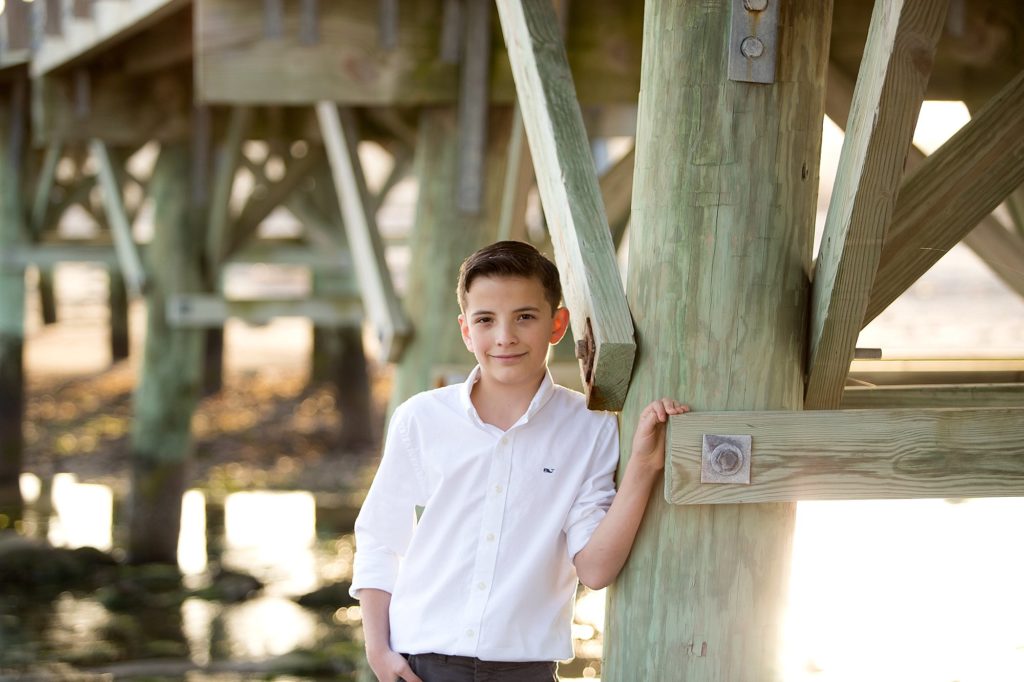 young man leans against pier