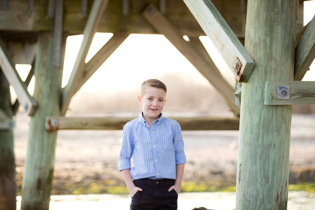 young boy poses on beach