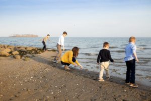 family skipping rocks at silver sands