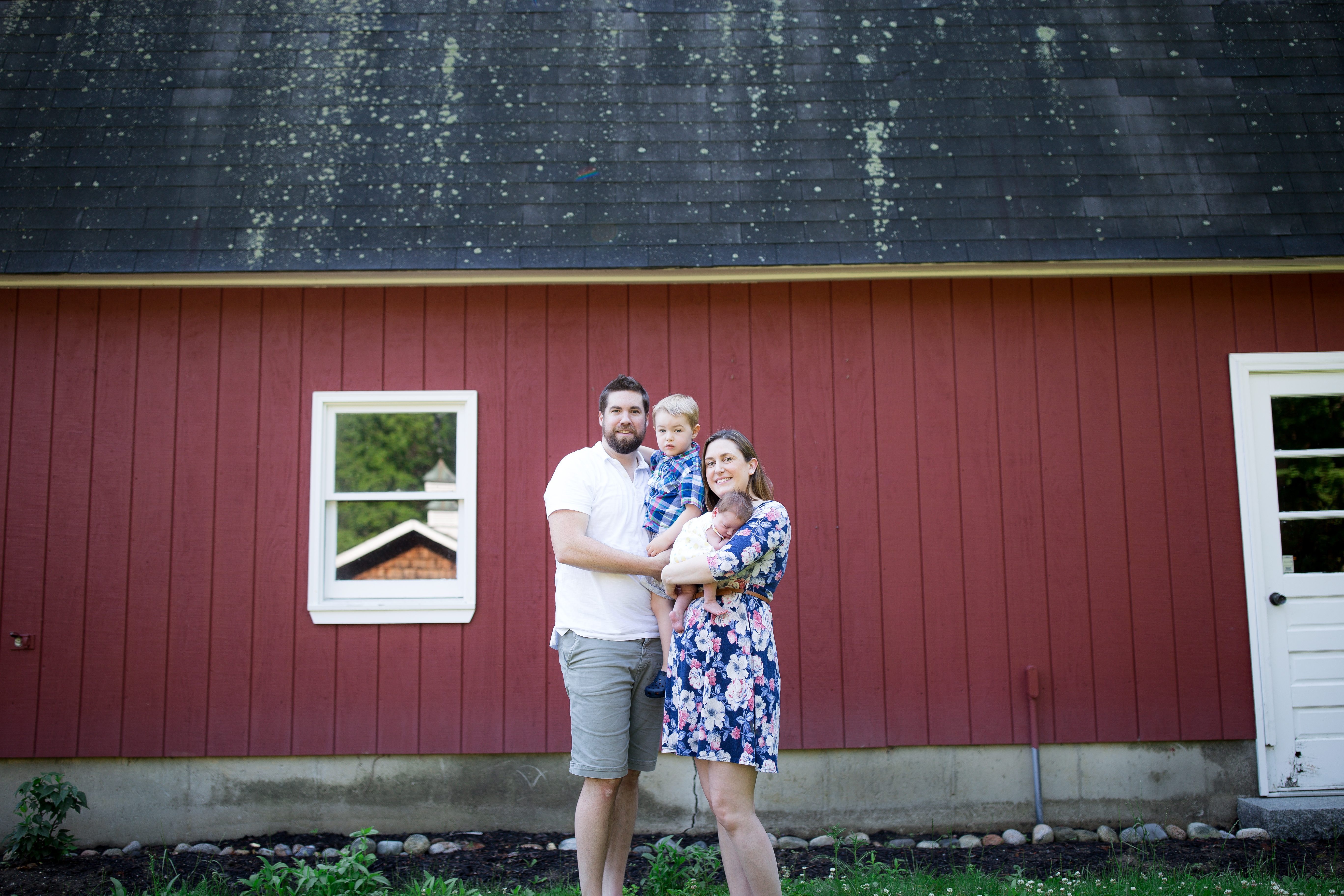 family in front of red bard