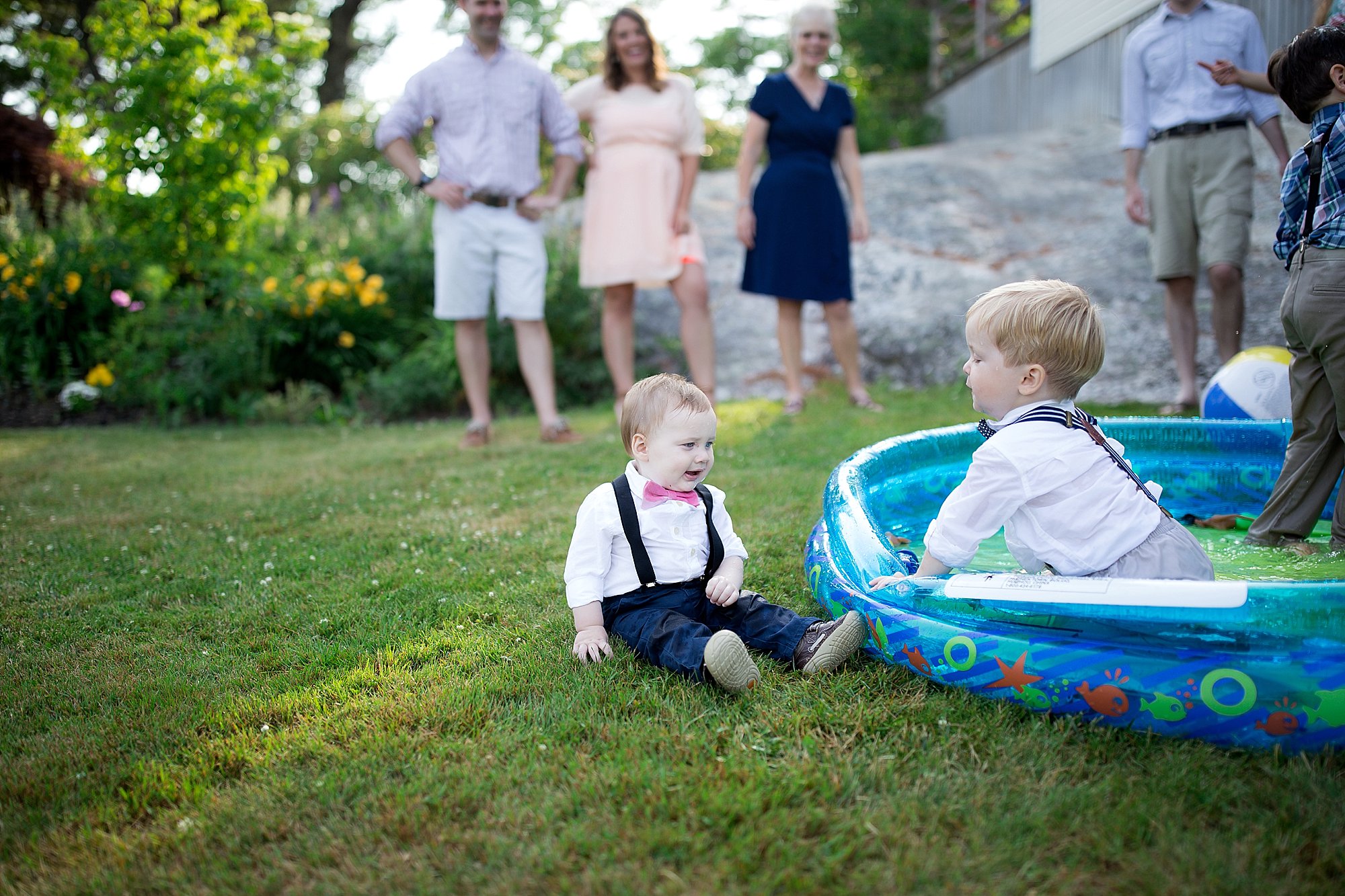 Boys dressed in suits play in kiddie pool