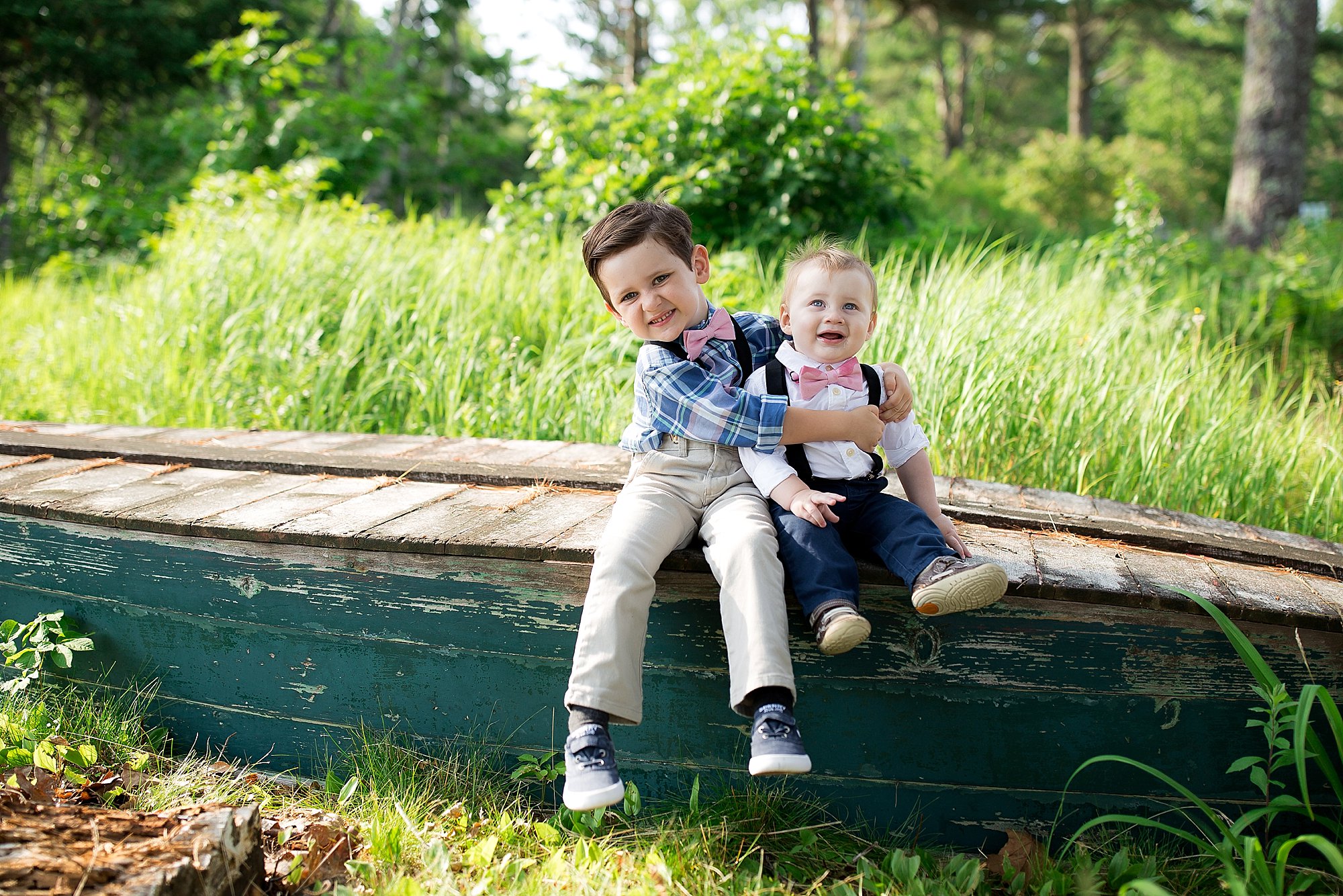 siblings pose on a canoe in Boothbay