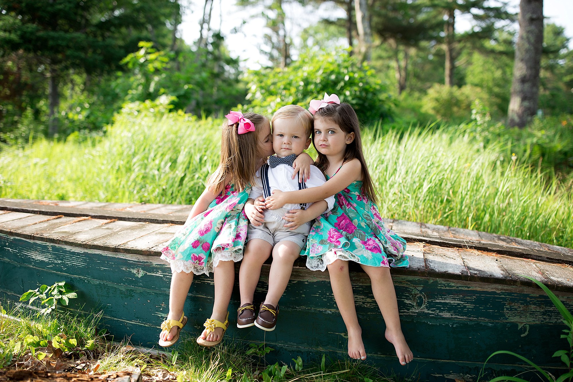 siblings pose on a canoe