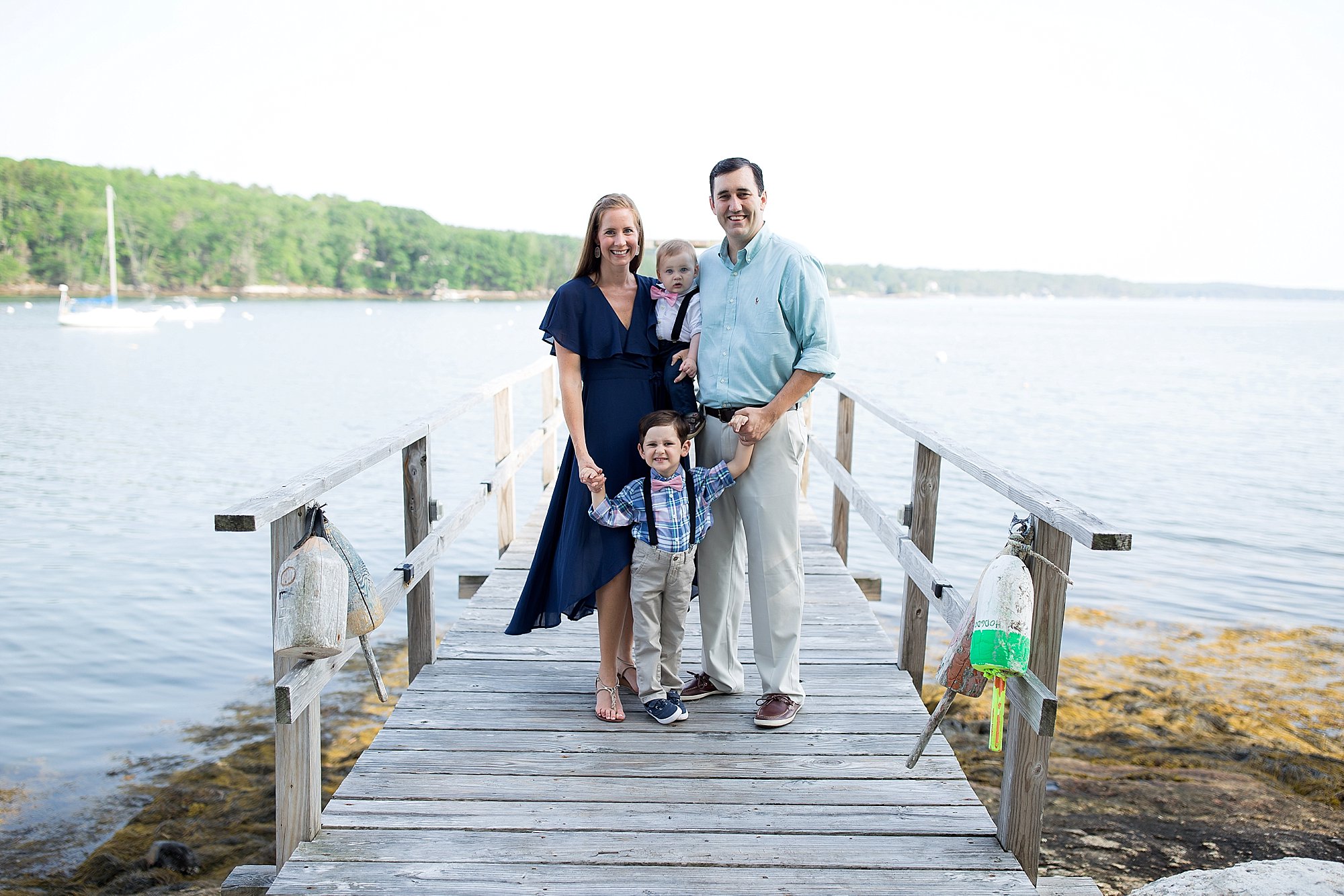 family poses on a pier at their Boothbay vacation house