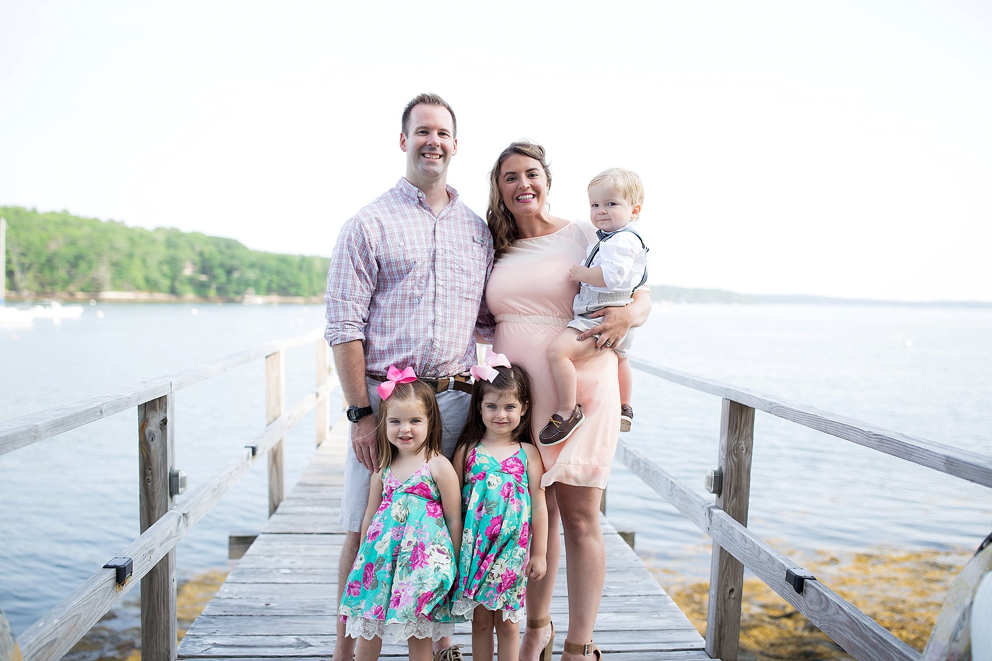 family poses on a pier in Boothbay Maine 