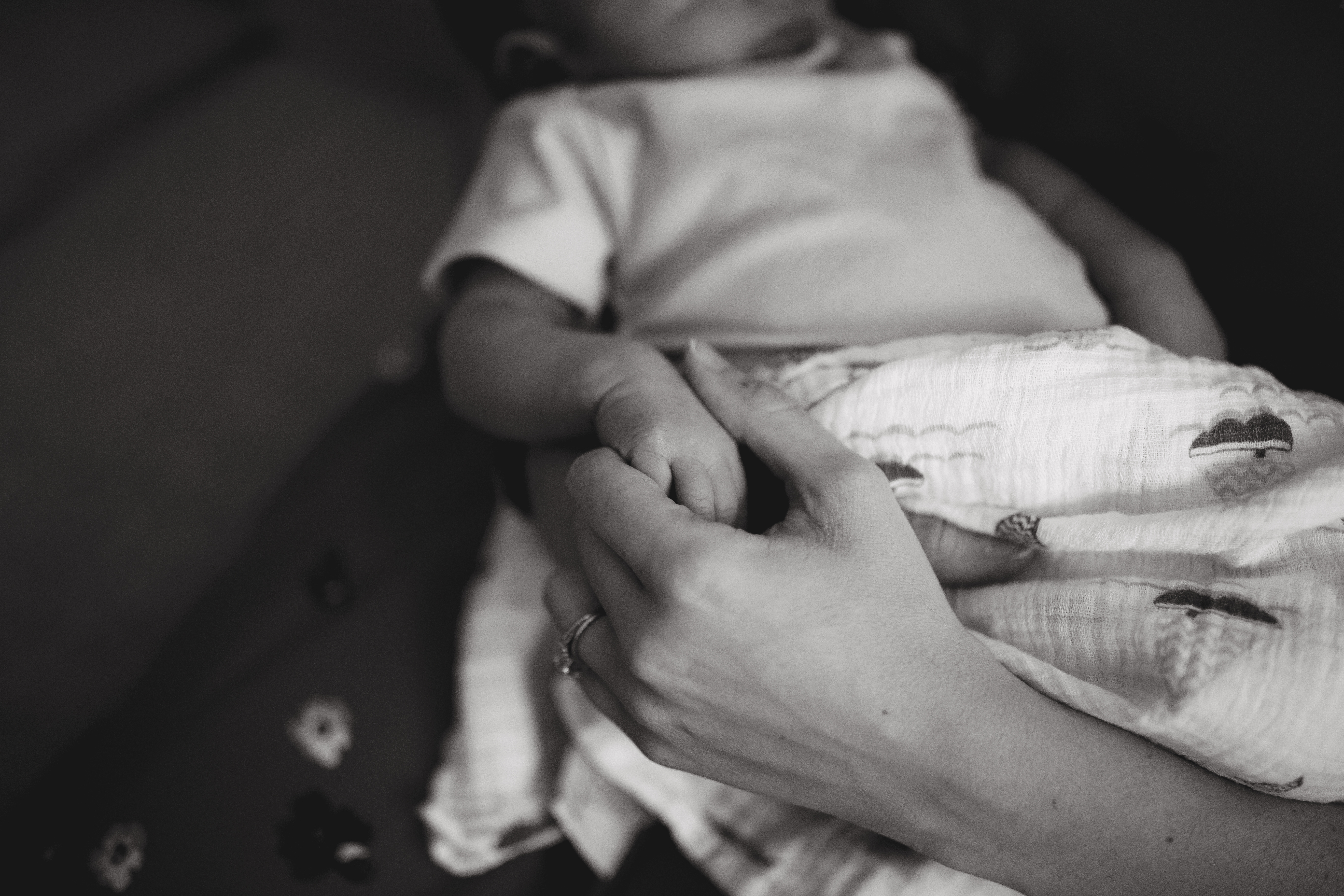 mom holding hands with newborns