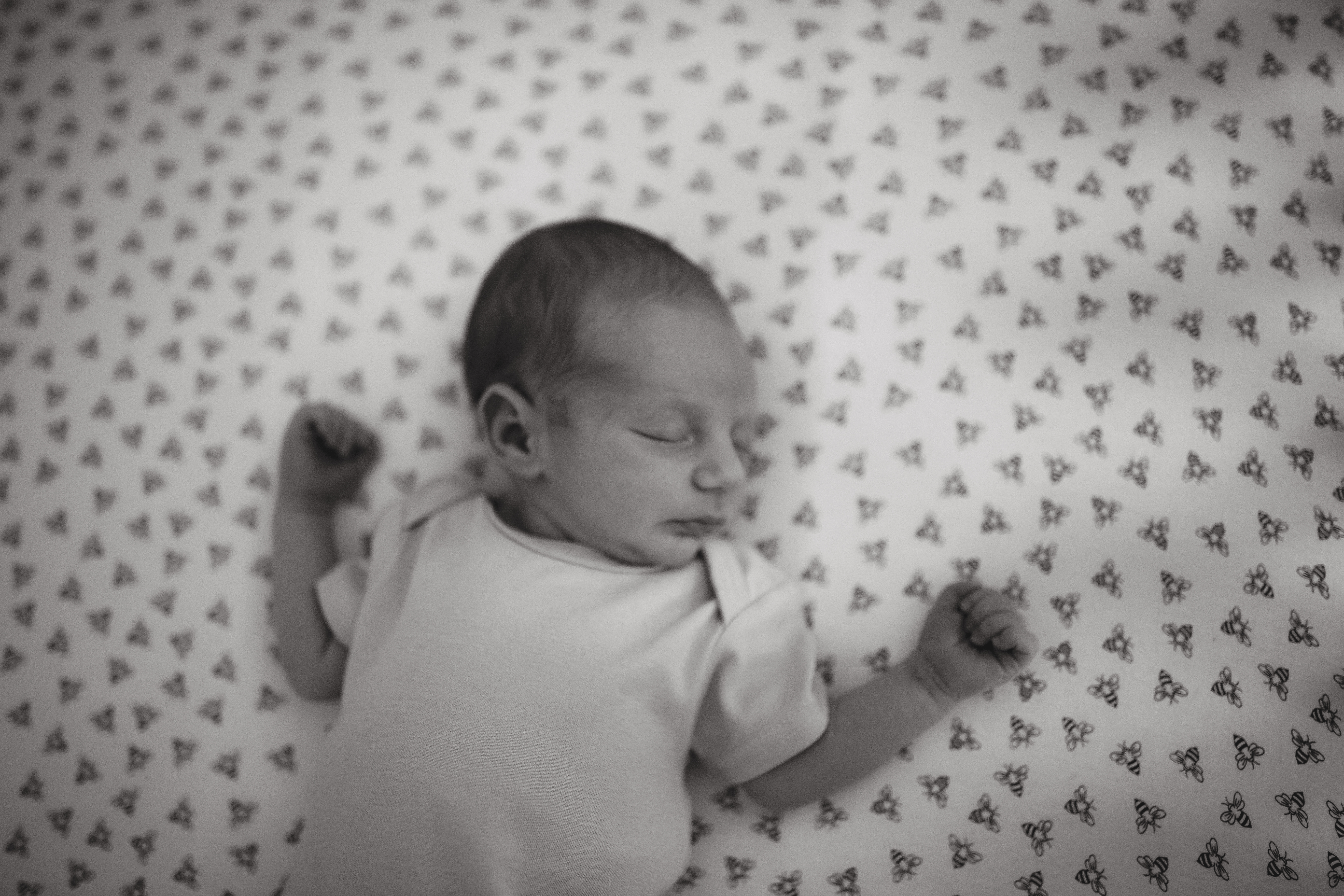 black and white image of baby boy sleeping in his nursery 