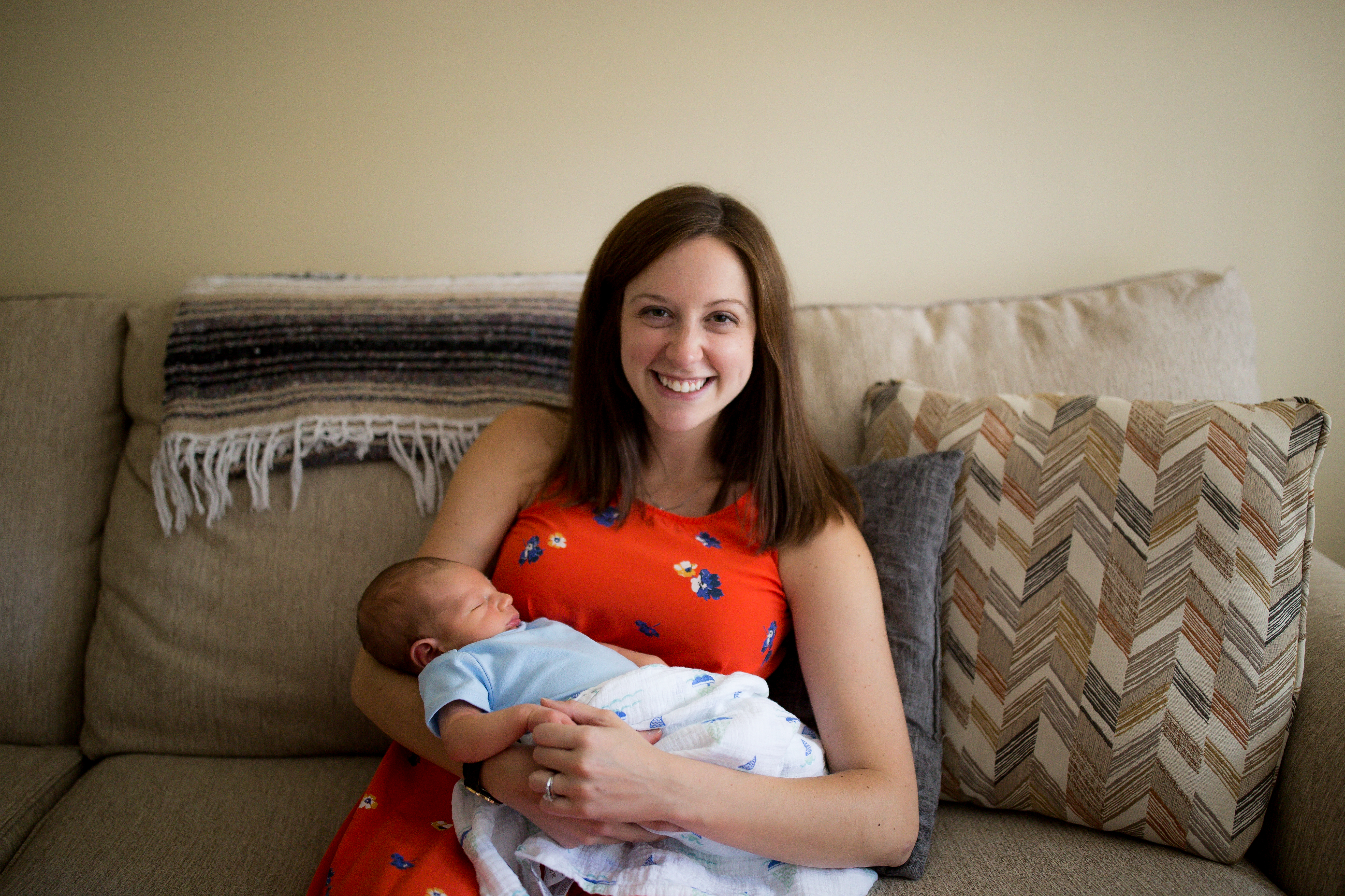mom holding newborn on couch