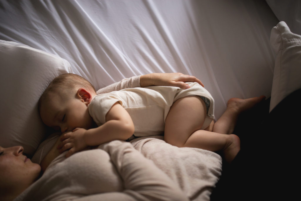 Mom and baby lay in bed together