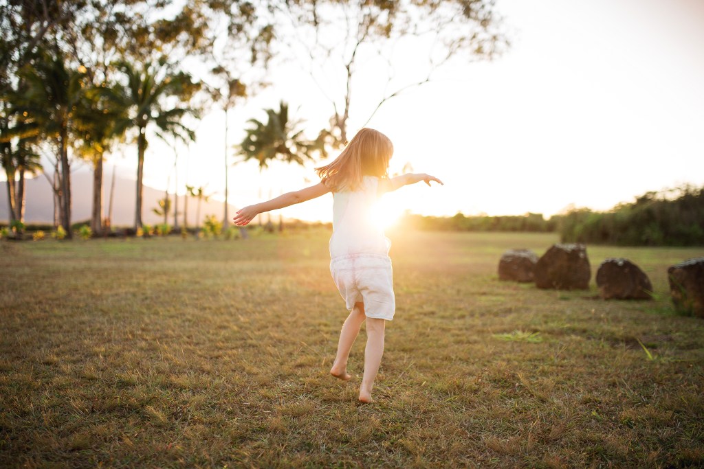 child dances in sunset