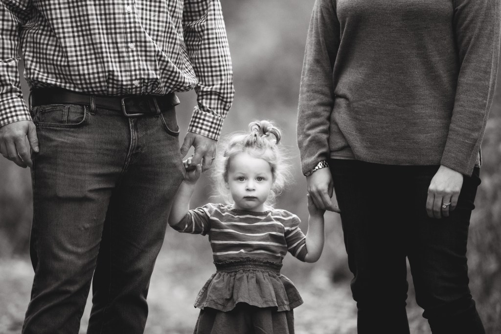 child holds parents hands