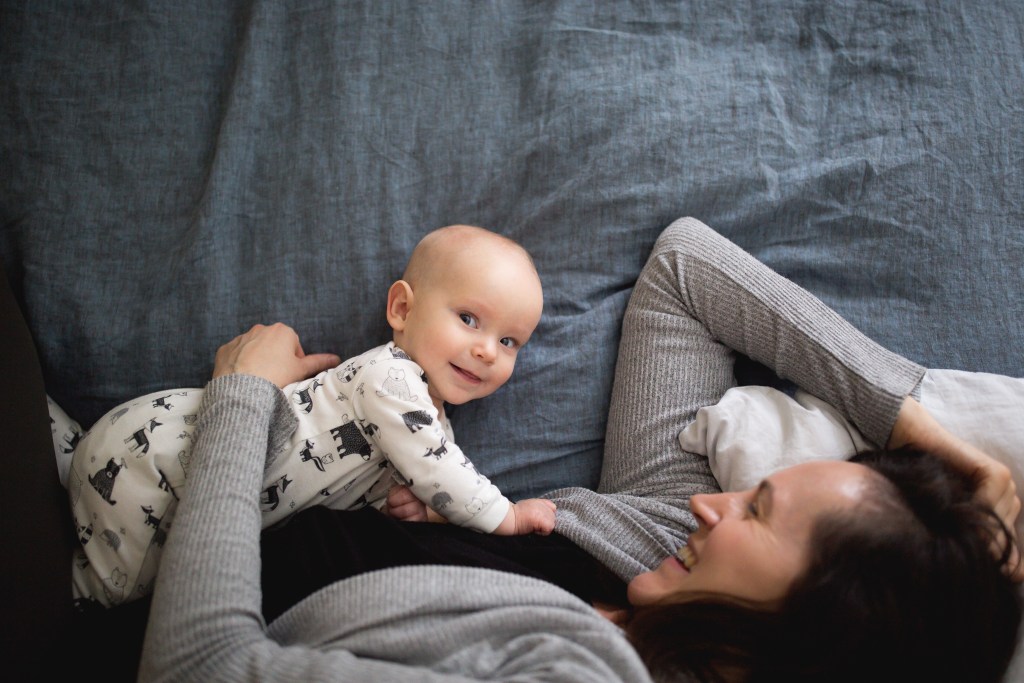 mother lays in bed with baby